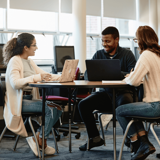 Two students meeting with an academic coach at a table in the Learning Commons