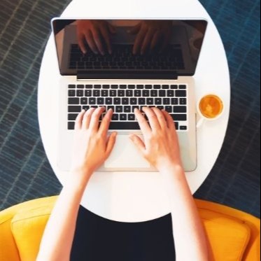 Aerial photo of an Apple laptop with someone typing