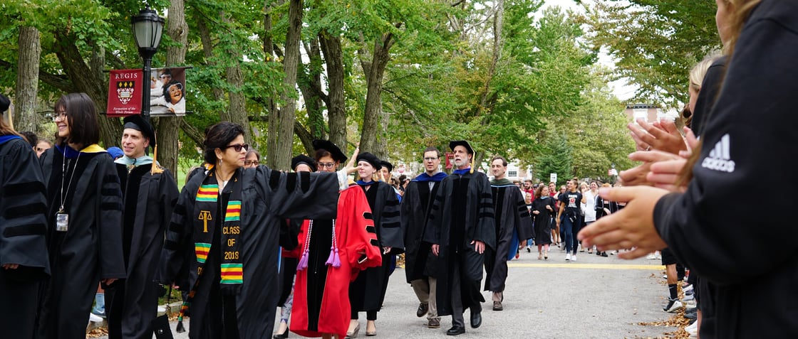 Faculty in academic regalia processing down Katsura Drive