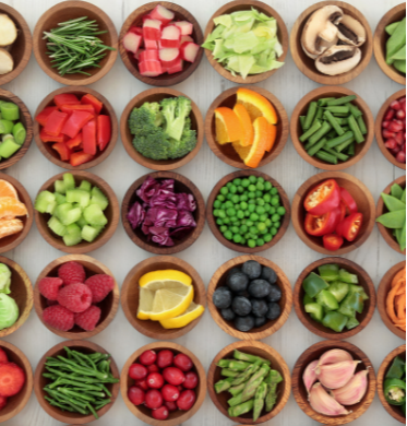 An aerial view of rows of chopped fruits and vegetables in small serving bowls