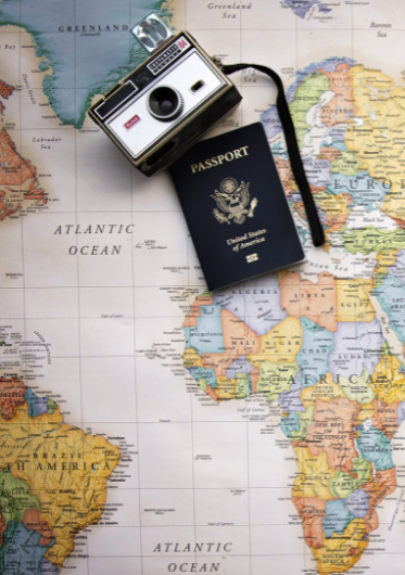 a camera and a U.S. passport laying on top of a world map