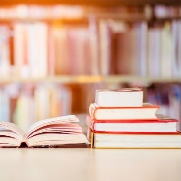 A stack of textbooks on a library table