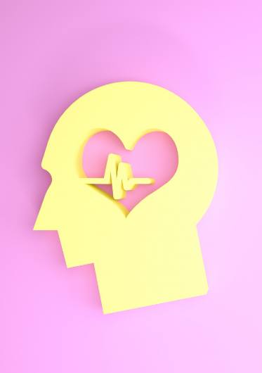 A yellow piece of paper cut into a silhouette of a human profile, with a heart where the brain would be
