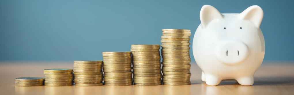  A piggy bank next to stacks of coins that are growing increasingly taller