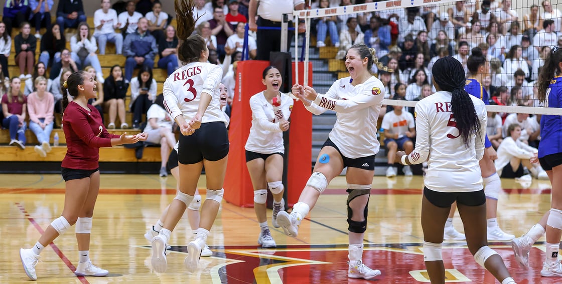 members of the Women's Volleyball team celebrating on the court